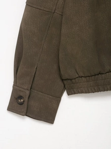 Detail of faux suede jacket with buttoned cuff and ribbed hem in dark olive brown