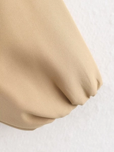 Detail of khaki puffer jacket showing ribbed elastic cuff and high-quality knit texture
