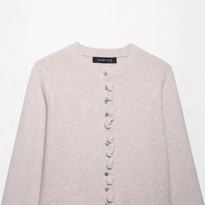 Elegant oatmeal knit cardigan with ruffled edges and pearl buttons in French style