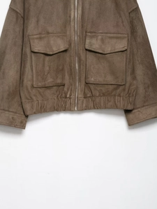 Detail of brown faux suede jacket with metal zipper and large utility pockets