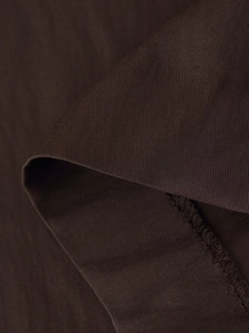 Detailed close-up of dark brown twill fabric with precision stitching on midi dress edge
