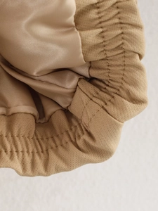 Detail of khaki jacket showing elastic cuff with twill texture and smooth satin lining