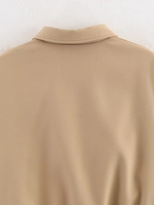 Detail of khaki puffer jacket showing the collar seam and woven fabric texture clearly