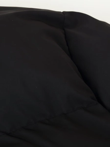 Detailed macro view of quilted black puffer jacket stitching and matte fabric texture