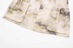 Détail d'une mini-jupe cargo avec imprimé camouflage, cordon élastique et arrêt de cordon