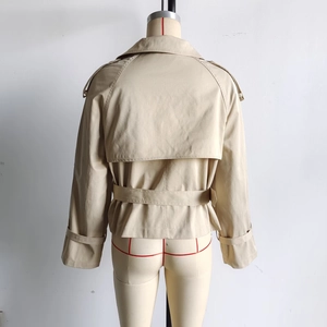 Detail view of khaki cropped trench coat back with storm flap and adjustable waist belt