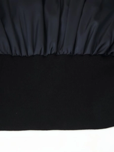 Detail of the black satin fabric seam and elastic ribbed knit cuff on the jacket