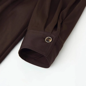 Deep brown long sleeve dress cuff with amber button detail and fine stitching