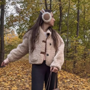 Wendejacke aus beigem Webpelz für Damen mit braunen Lederdetails im herbstlichen Wald