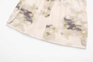 Détail d'une mini-jupe avec motifs abstraits verts et gris et une poche latérale