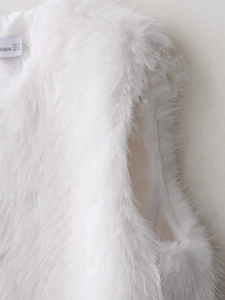 Detail of white faux fur vest showing plush texture and smooth silk-like inner lining
