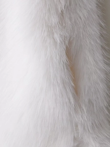 Close-up macro detail of fluffy white faux fur fabric with soft long hair texture