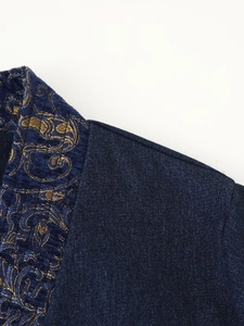 Detail of vintage gold jacquard pattern on dark blue denim kimono jacket collar