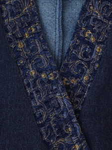 Macro detail of navy denim jacket featuring gold floral embroidery on velvet trim