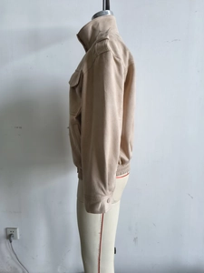 Detail view of beige suede jacket showing stand collar, epaulettes and zip closure