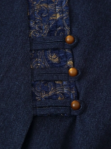 Detail of dark blue jacquard fabric with gold embroidery and vintage buttons