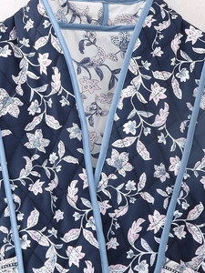Close-up of quilted floral pattern jacket with light blue trim and vintage prints