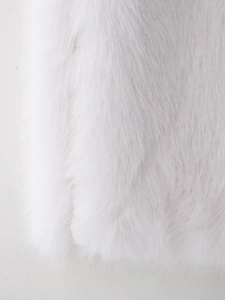 Detailed close-up of white faux fur texture showing soft plush and dense long fibers