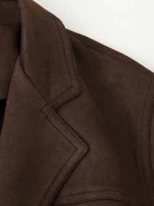 Detailed close-up of brown suede jacket lapel with premium stitching and texture