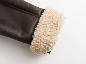 Dettaglio macro del polsino della giacca in pelle marrone con fodera in shearling