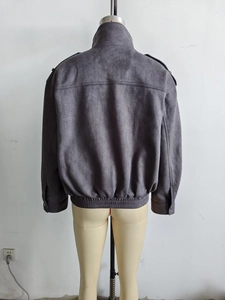 Detail view of the back of a grey faux suede jacket featuring a stand collar and epaulets