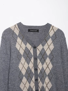 Macro shot of V-neck opening and dark buttons on Argyle knit cardigan sweater