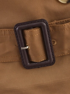 Close-up of a brown short trench coat belt with a resin buckle and twill fabric detail