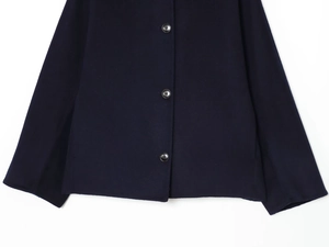 Detailed view of heavy navy wool jacket with three black round buttons on front placket