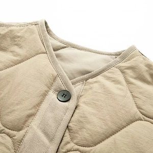 Close-up of khaki quilted jacket featuring gourd stitching and herringbone trim