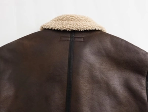 Dettaglio del colletto in shearling e cuciture della giacca da pilota in pelle marrone