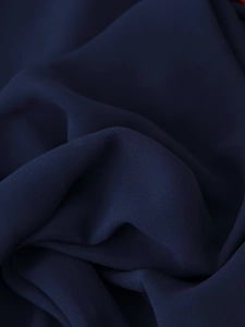 Close-up of dark blue textured fabric with tassels and soft elegant drapes