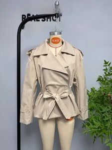 Detail of light khaki short trench coat with waist belt and double-breasted buttons