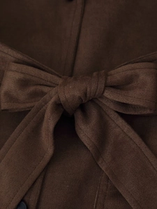 Macro detail of dark brown faux suede jacket waist with tied bow belt design