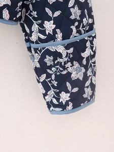 Detail of floral print quilted jacket with diamond stitching and light blue trim