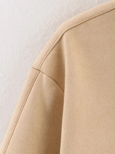 Detailed macro view of light camel faux suede jacket showing seam stitching and soft fabric