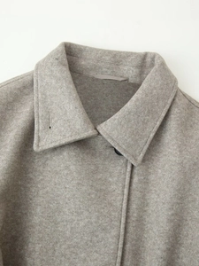 Detail of notch lapel on soft wool blend coat with premium button and stitching