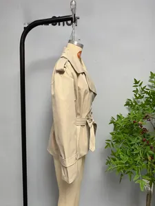 Detailed side view of khaki trench coat featuring classic epaulettes and a tied waist belt
