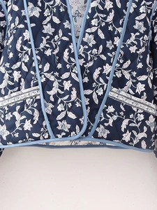 Detail of floral quilted jacket featuring navy blue base with pink flowers and diamond stitching