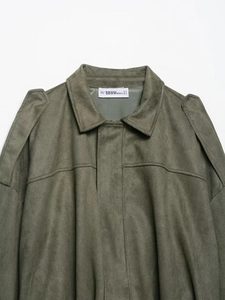 Gros plan détaillé du col et de l'étiquette d'une veste en daim vert olive foncé