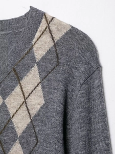 Close-up of grey knit cardigan featuring argyle pattern and V-neck collar detail