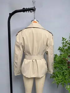 Rear view of a beige short trench jacket with epaulettes and waist belt on a mannequin