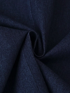Macro detail of dark blue denim fabric texture with fine twill weave and stitching