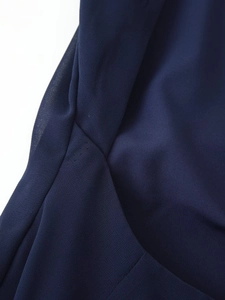 Detailed close-up of navy blue dress fabric texture with high-quality stitching and seam