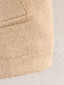 Detailed close-up of apricot suede jacket hem with premium stitching and wool texture
