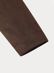 Detail of dark brown faux suede sleeve cuff with fine knit texture and neat stitching