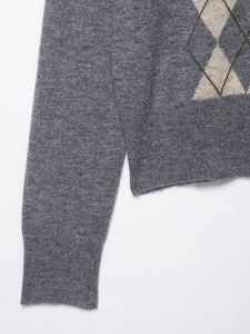 Detail of argyle knit cardigan showing grey diamond pattern and ribbed cuffs texture