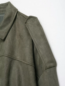 Détail de la veste aviateur en daim vert montrant le col et les pattes d'épaule avec coutures