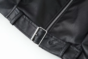 Detailaufnahme der Vintage-Lederjacke in Braun mit verstellbarem Gürtel und Silberschnalle