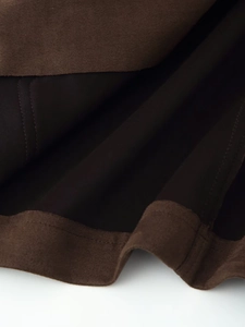 Detail of dark brown faux suede jacket fabric with precise stitching and inner lining