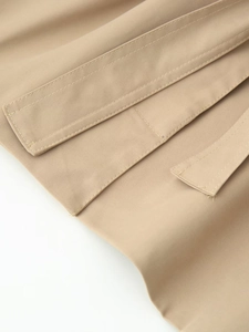 Detail of premium khaki twill fabric with precision stitching on cropped trench coat